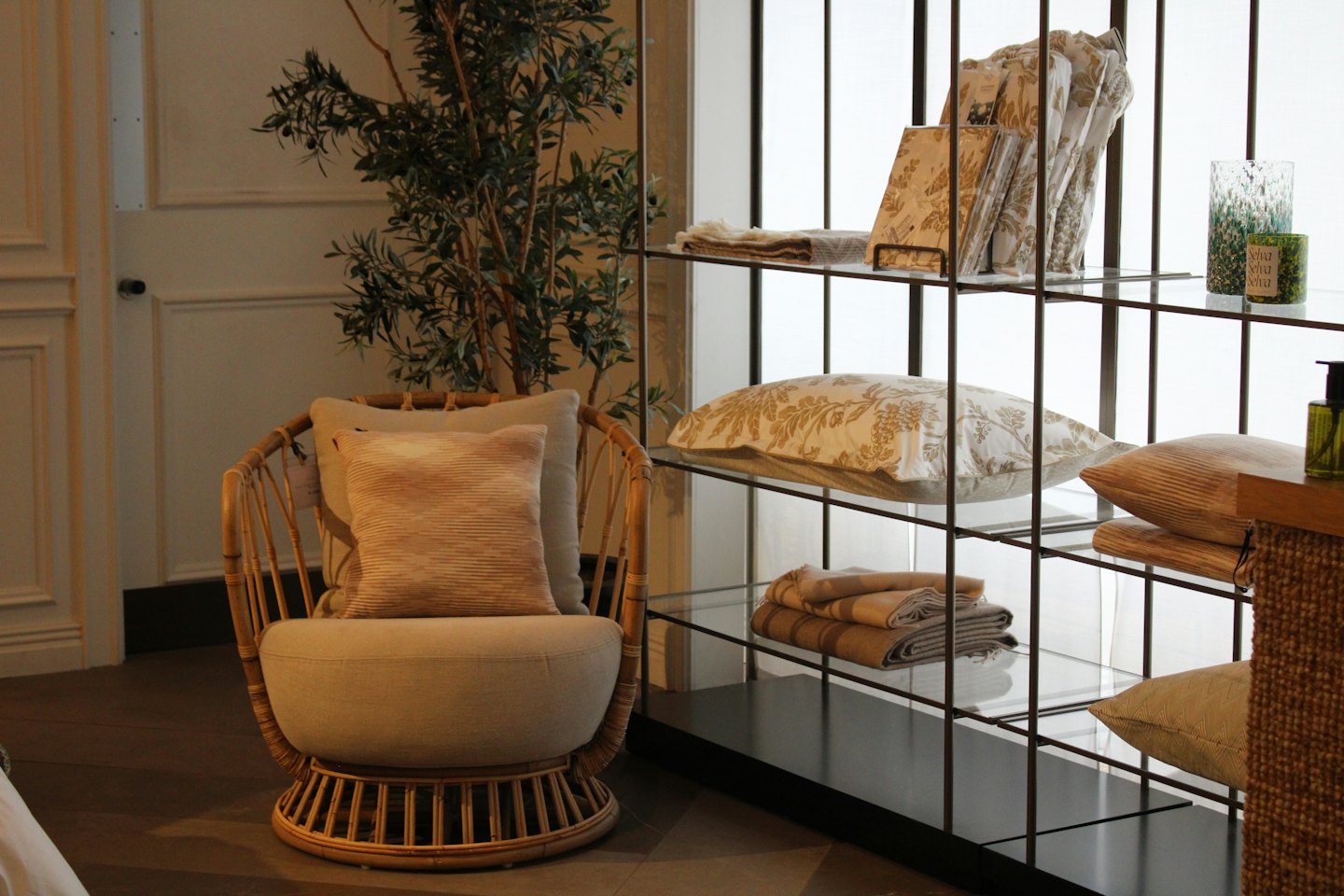 Poltrona in rattan e scaffalatura decorativa in un soggiorno moderno.